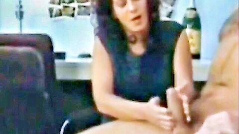 Curly-haired MILF giving handjob to man in black top