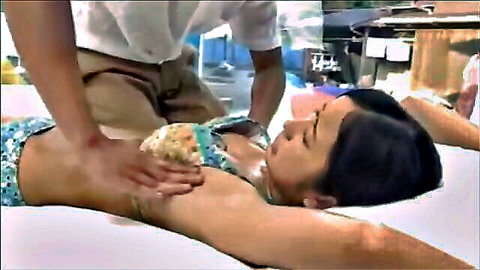 Japanese woman in teal bikini gets sensual massage on table