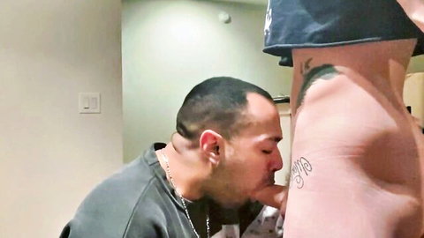 Latino man kneeling to perform oral sex on tattooed woman's exposed pussy