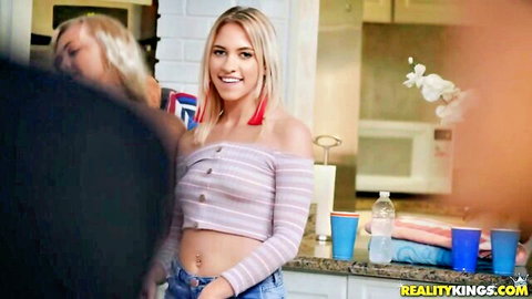 Blonde babe in skimpy striped off-shoulder crop top smiles at kitchen party with solo cups