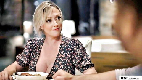Blonde MILF in deep cleavage floral dress smiling seductively at dinner exposing big tits