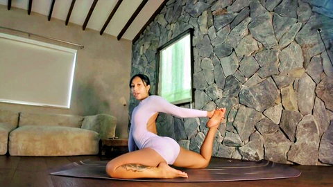 Flexible Asian woman in tight purple bodysuit doing hip-opening yoga pose