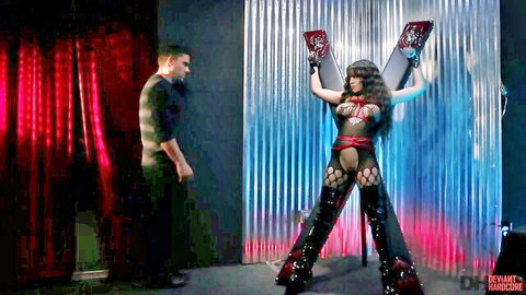 Luna Star in black fishnet lingerie, arms raised in bondage pose