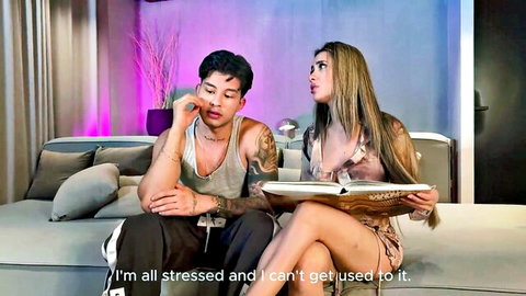 Stressed tattooed Latino guy comforted by sexy long-haired blonde girlfriend on couch