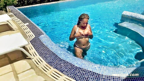 Ebony babe squeezing her big tits through wet white bikini in pool