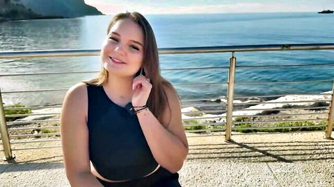 Lily, 23yo Parisian beauty smiling by the sea in black tank top