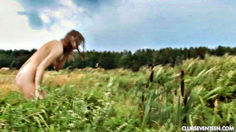 Nude brunette teen bends over in grassy field exposing perfect shaved pussy and ass outdoors