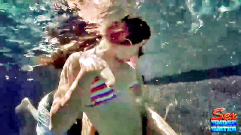 Wet underwater fair-skinned babe in rainbow triangle bikini top with flowing long hair and curvy wet body