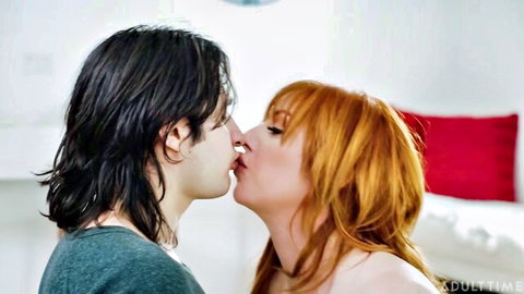 Redhead MILF passionately kissing long-haired stud in bedroom