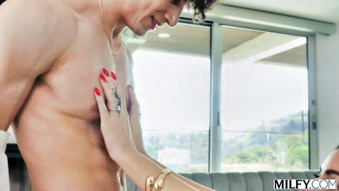Sexy MILF with red nails gropes muscular stud's ripped chest in teasing foreplay