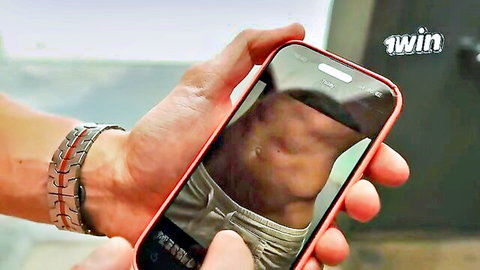 Muscular guy flexing ripped abs in low-rise white underwear on phone screen reflection