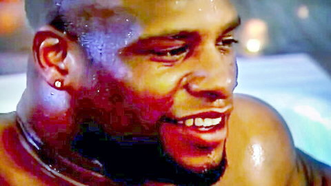 Sweaty muscular black man smiling closeup with wet glistening skin and diamond earring