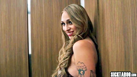 Blonde babe with huge tits and cloud tattoo smiling seductively in low-cut top
