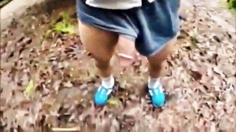 Hairy guy lifts short blue skirt exposing thick cock and balls outdoors on park dirt path