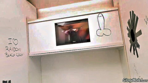 Big black cock protruding through glory hole in bathroom stall with I love BBC graffiti
