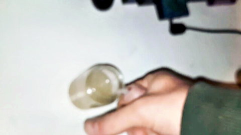 Hand holding jar of creamy semen from ten cum loads in amateur collection