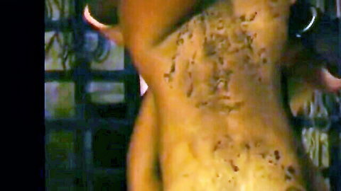 Nude woman bent over showing marked back and ass in impalement fetish