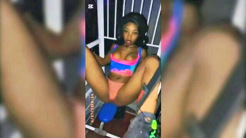 Ebony babe with big tits spreads legs wide on blue exercise bike teasing pussy through orange shorts in jail