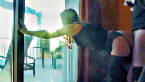 Amateur woman in black dress and stockings bending over on balcony for anal sex
