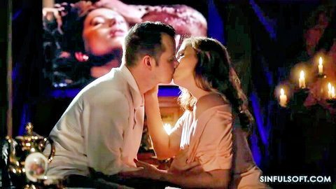 Passionate couple kissing intensely in candlelit room with erotic movie screen background