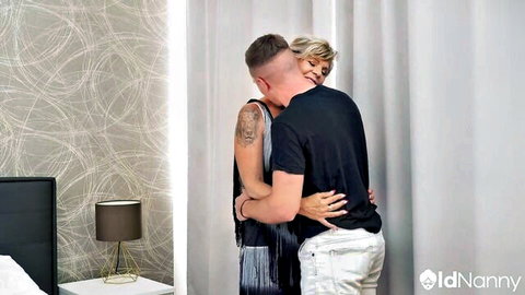 Duncan Sheen hugs mature blonde woman in fringed dress from behind