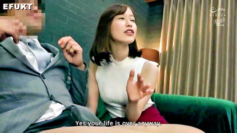 Asian woman in white tank top and red skirt sits with suited man on couch