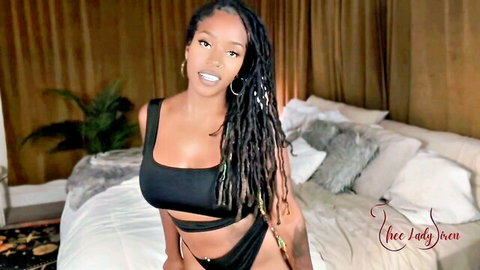 Ebony babe with big tits in skimpy black bikini posing seductively on bed