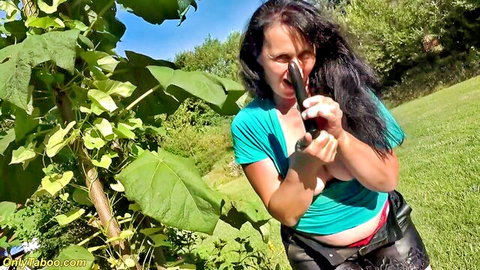 Mature woman in blue top and leather pants enjoys sensual outdoor solo play