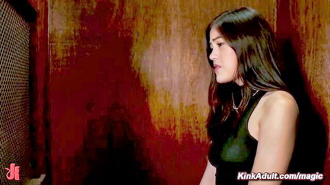 Asian woman in black tank top, seductive profile in lesbian anal video