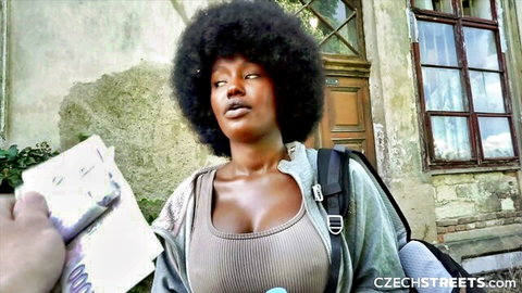 Cute busty black girl with big afro holding cash, deep cleavage in gray tank top