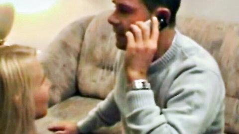 Blonde woman chats intimately with man on phone in European adult scene
