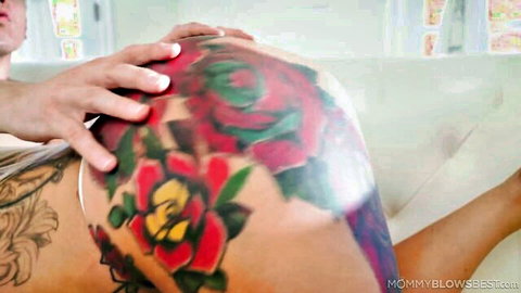 Man's hand spreading tattooed MILF's bare juicy ass cheeks on couch