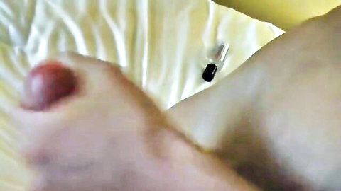 Close-up of swollen red big toe on foot with black capsule nearby, foot fetish tease
