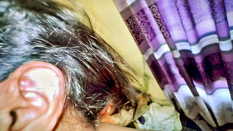 Close-up of chubby stepmom's ear and gray hair during tease, purple curtain background