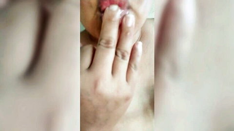 Blurry close-up of Latina woman's red lips and hand teasing oral play, wanting big black cock