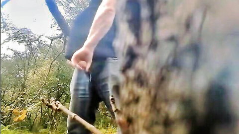 Man cruising in woods, hand near crotch, outdoor gay encounter preview