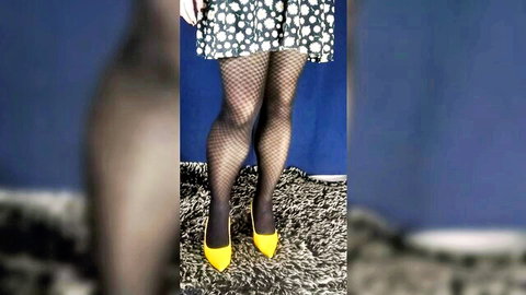Seductive woman in checkered mini dress, fishnet tights, yellow high heels