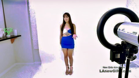 Brunette Latina in short blue dress posing in studio