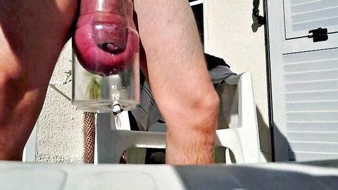 Hairy man's throbbing big cock sucked deep into clear transparent suction tube outdoors