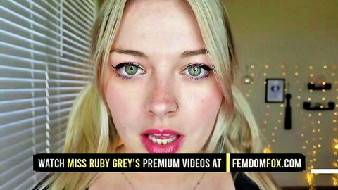 Blonde femdom mistress Miss Ruby Grey teases with glossy pouty lips and green eyes in closeup