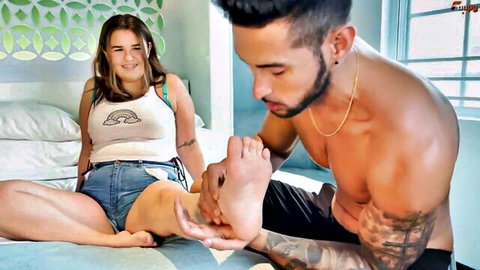 Muscular tattooed guy licks and worships curvy brunette teen's bare foot toes