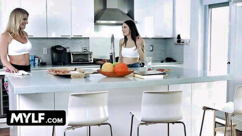 Blonde and brunette MILFs in white bras tease curves seductively in modern kitchen