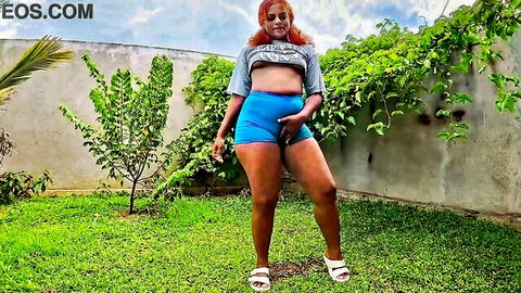 Curvy redhead Nilmini Sheron in tight blue shorts and crop top try-on pose