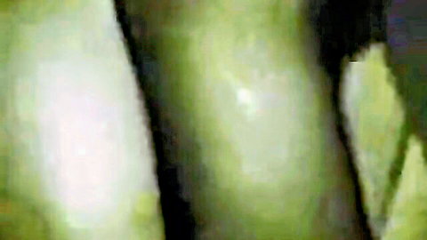 Blurry green-tinted close-up of muscular thighs and skin in amateur gay action