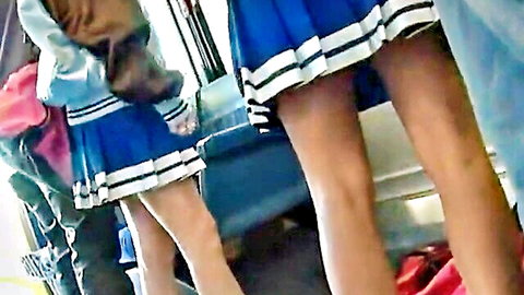 Two Asian schoolgirls in short blue pleated skirts on public bus upskirt view