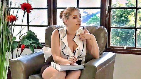 Seductive blonde therapist in low-cut blouse and skirt, thoughtful pose with notebook