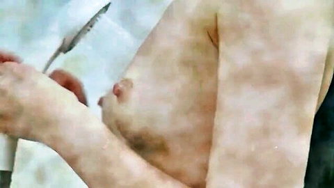 Asian MILF exposing medium breast while holding knife in topless scene
