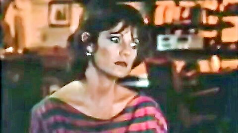 Surprised mature brunette in off-shoulder striped top showing cleavage in retro kitchen