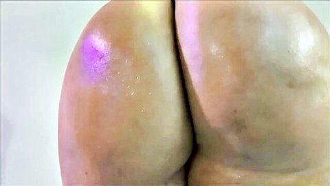 Shiny phat booty close-up with purple oil shimmer