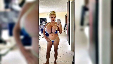 Busty blonde bombshell posing in tiny blue bikini selfie